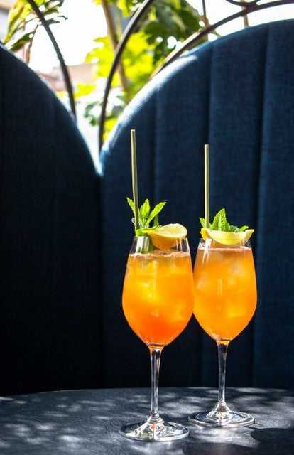 Two Chai Tai cocktails, garnished with orange slices and mint leaves.