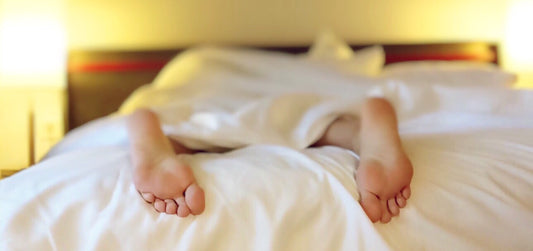 Person sleeping, view of their feet sticking out of blankets