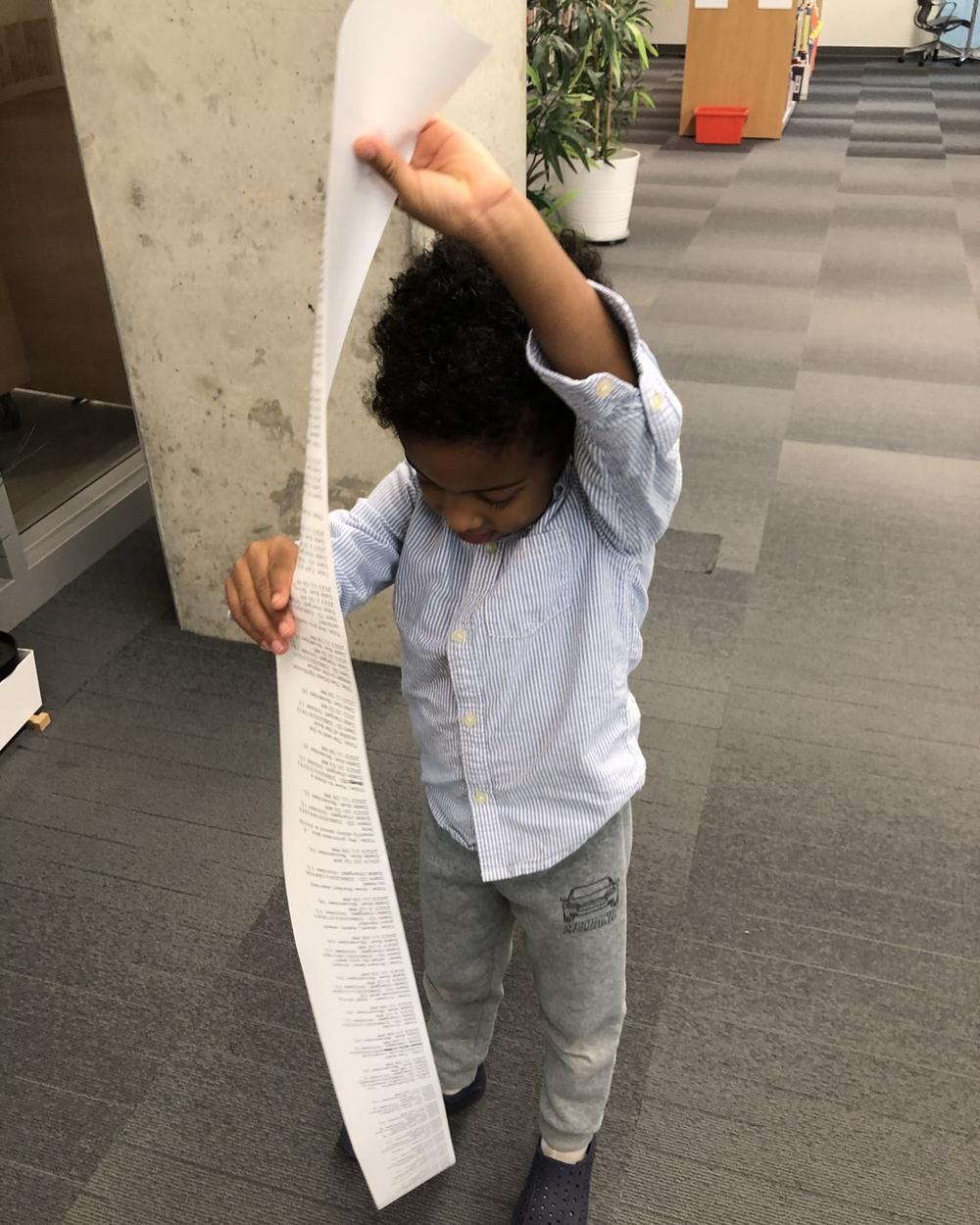 Cash in a library, holding up a very long printed receipt