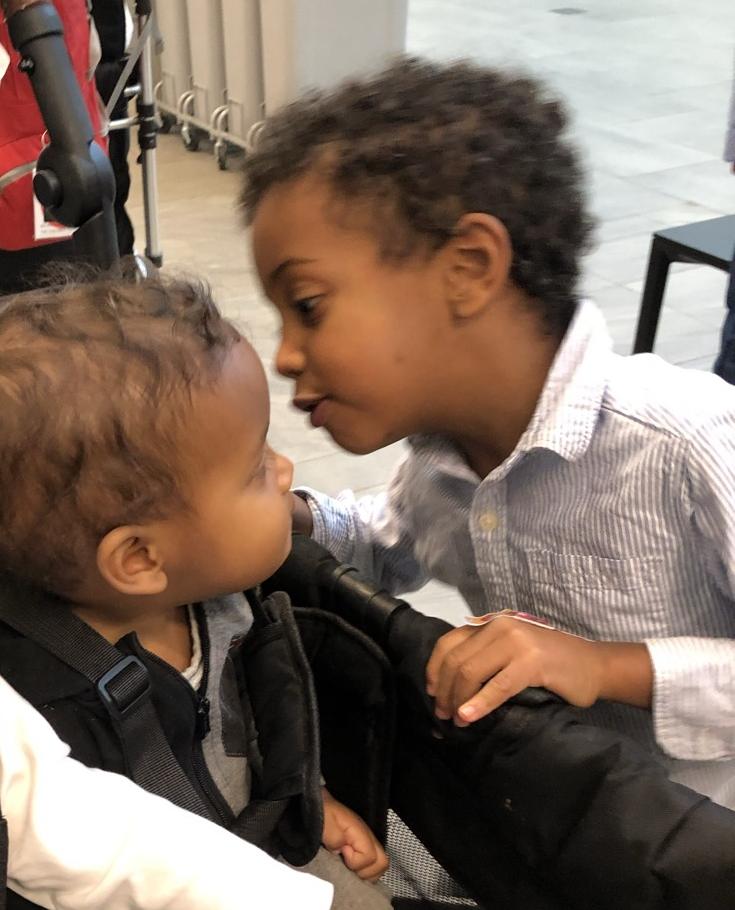 Cash leaning in close to say hello to his little brother Roman, who is sitting in a stroller